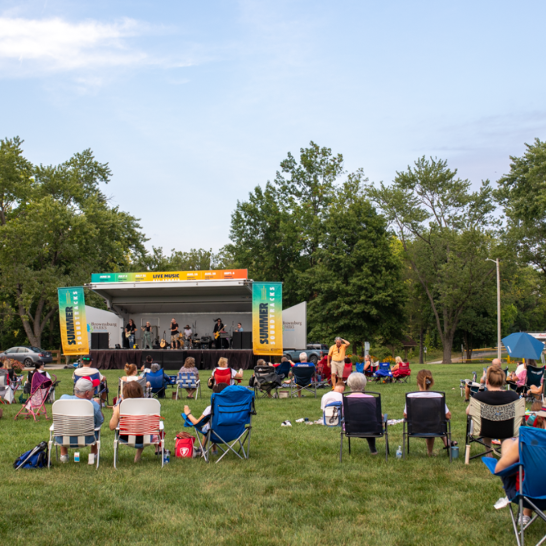 People gathered in front of a stage while musicians play music